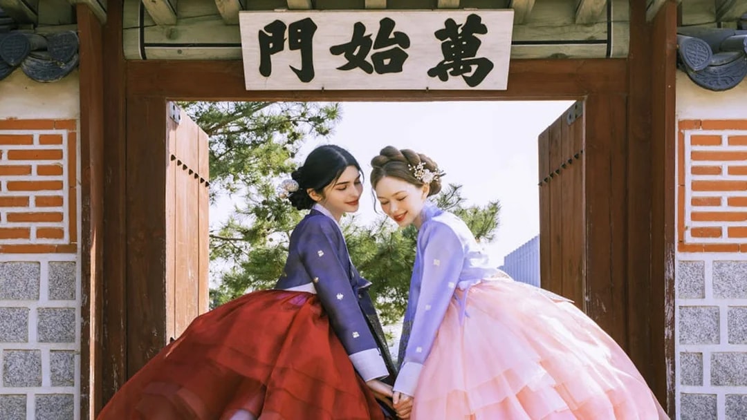 Two people in traditional hanbok at Gyeongbokgung Palace, Seoul.