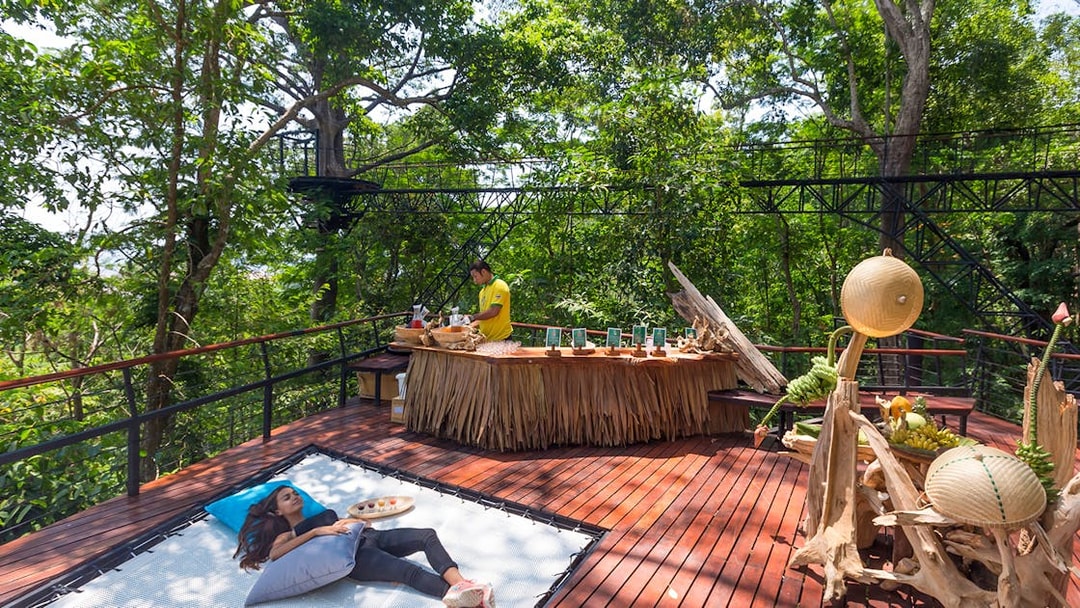 Woman relaxing on a deck in a forest setting, Phuket, Thailand.