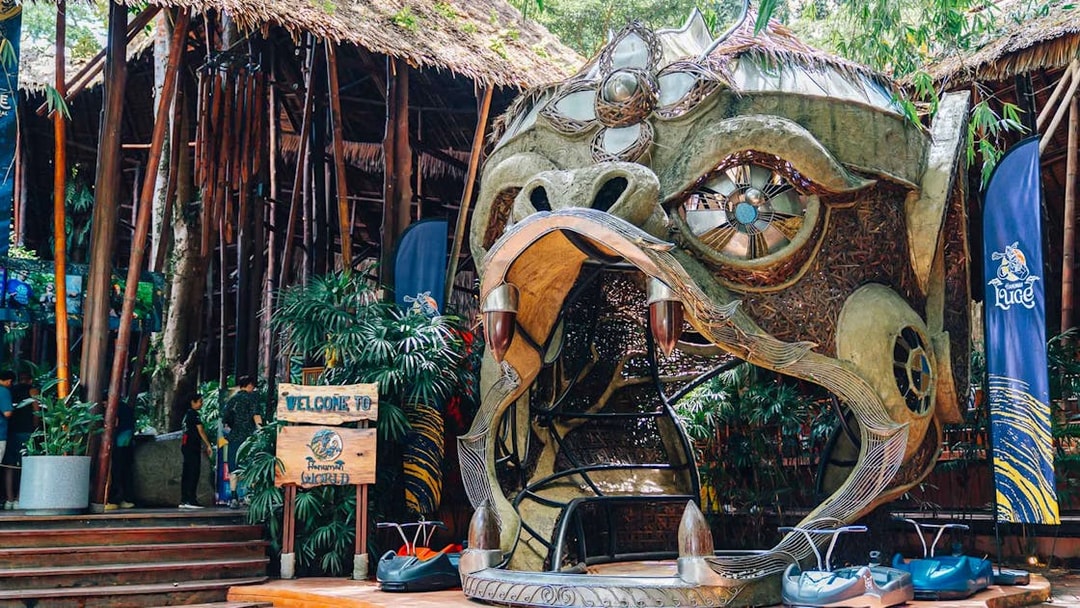 Hanuman World entrance with decorative sculpture and zipline carts in Phuket, Thailand.