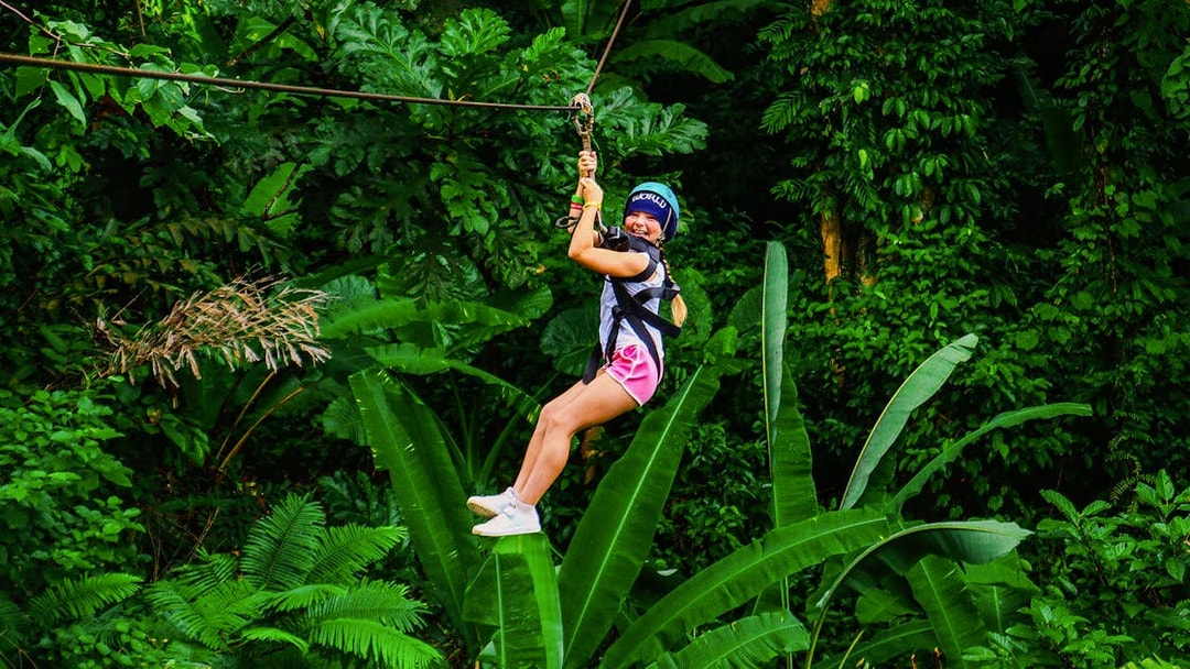 Zip lining through lush forest at Hanuman World, Thailand.