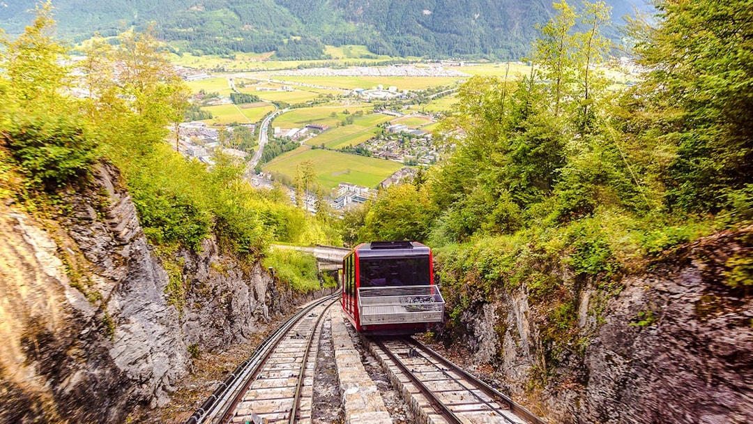 Funicular ascending Harder Kulm with scenic view of Interlaken and surrounding mountains.