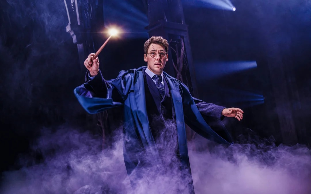 Actor performing magic scene in "Harry Potter and the Cursed Child" on Broadway stage.