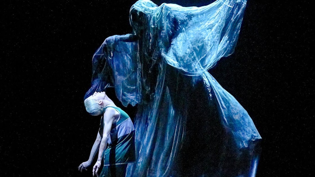 Stage scene from "Harry Potter and the Cursed Child" with a ghostly figure looming over a character.