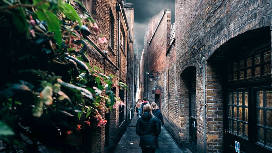 Walking tour group in narrow London alley, Harry Potter film location.