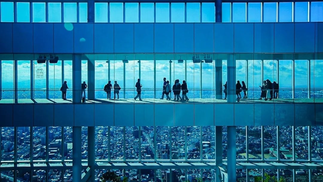 Visitors at HARUKAS 300 Observatory with Osaka skyline view.