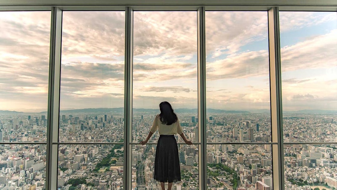Woman viewing Osaka skyline from Harukas 300 Observatory.