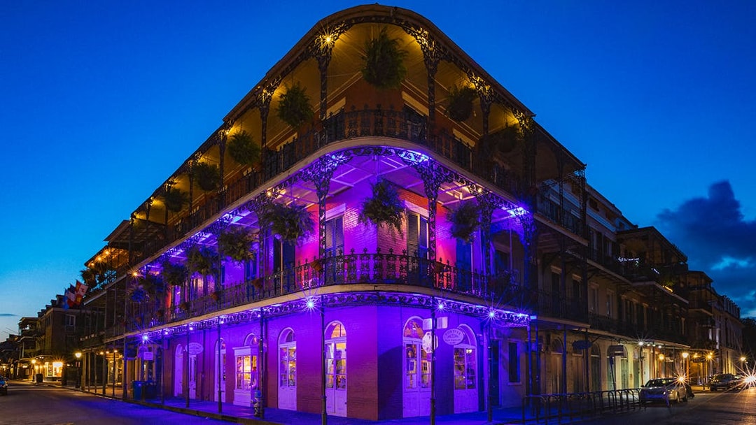 Bourbon Street balconies illuminated at night in New Orleans.