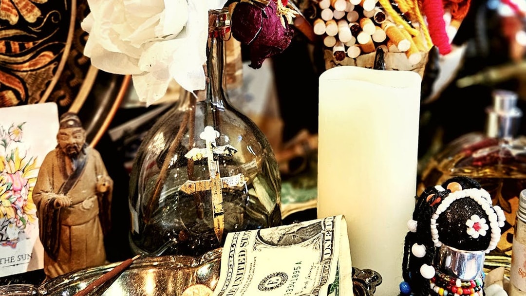 Voodoo artefacts with cross, candle, and figurine on New Orleans Haunted Ghost, Voodoo & Vampire Tour.
