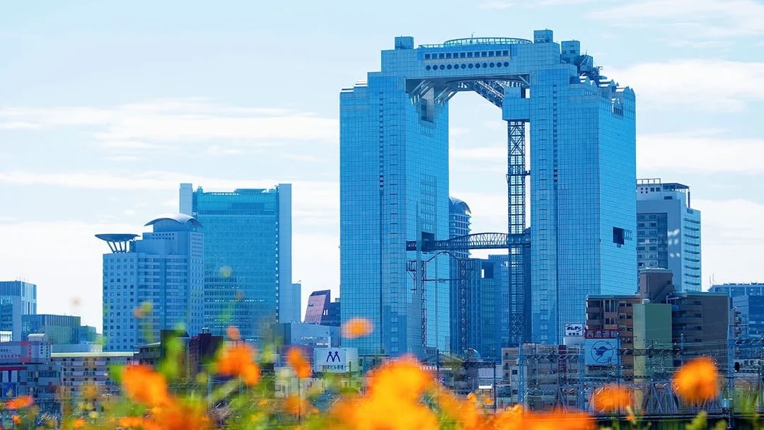Umeda Sky Building in Osaka with orange flowers in the foreground.