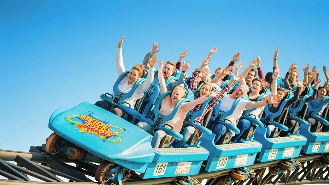 Roller coaster riders with raised hands at Heide Park.