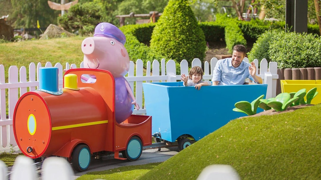 Child and adult on a colorful train ride at Heide Park.