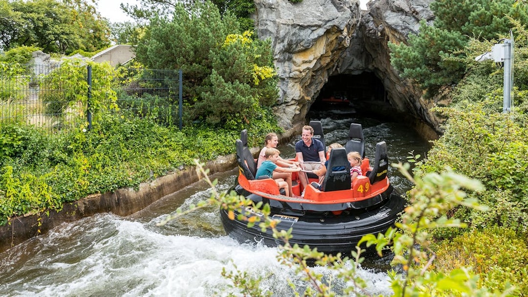 Raft ride at Heide Park with visitors entering a rocky tunnel.