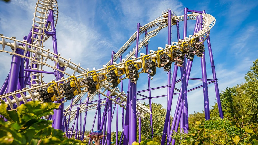 Roller coaster at Heide Park with riders on a loop against a blue sky.