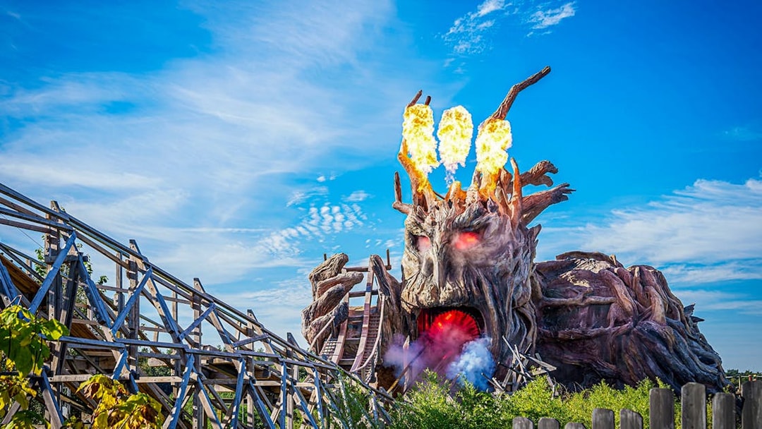 Heide Park wooden roller coaster with fiery tree sculpture.