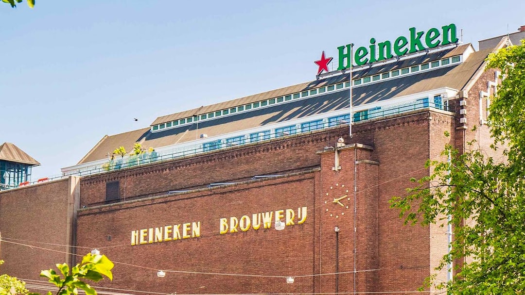 Heineken Brewery building in Amsterdam with signage and clock.