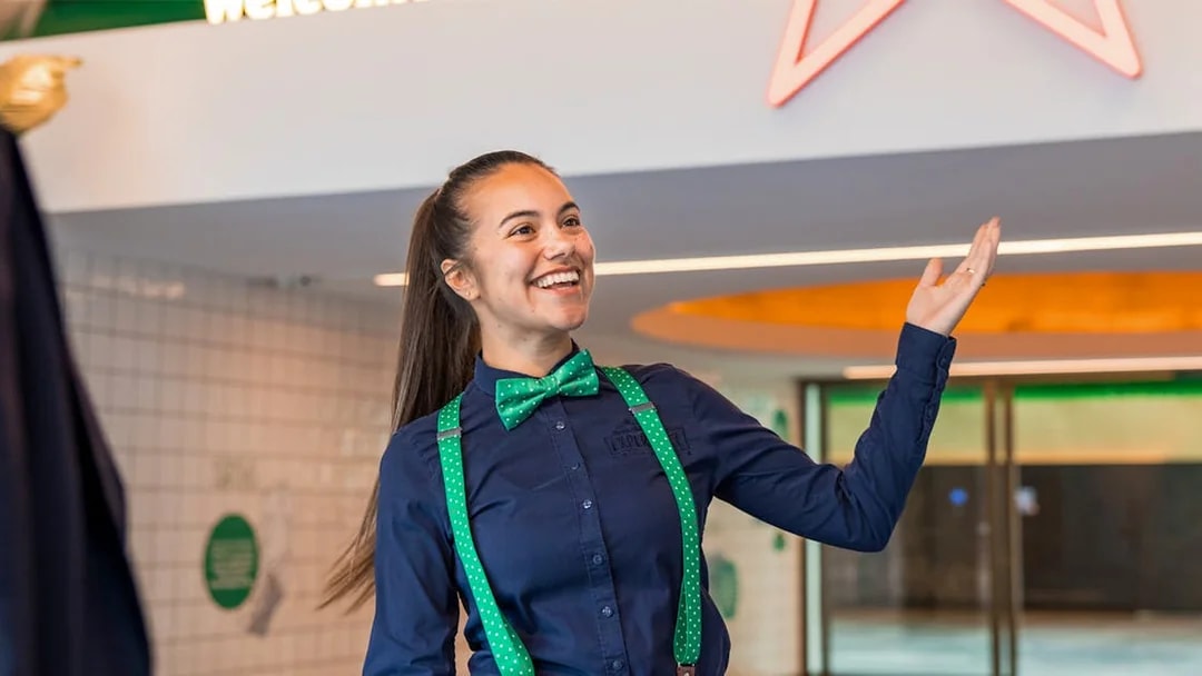 Guide welcoming visitors at Heineken Experience in Amsterdam.