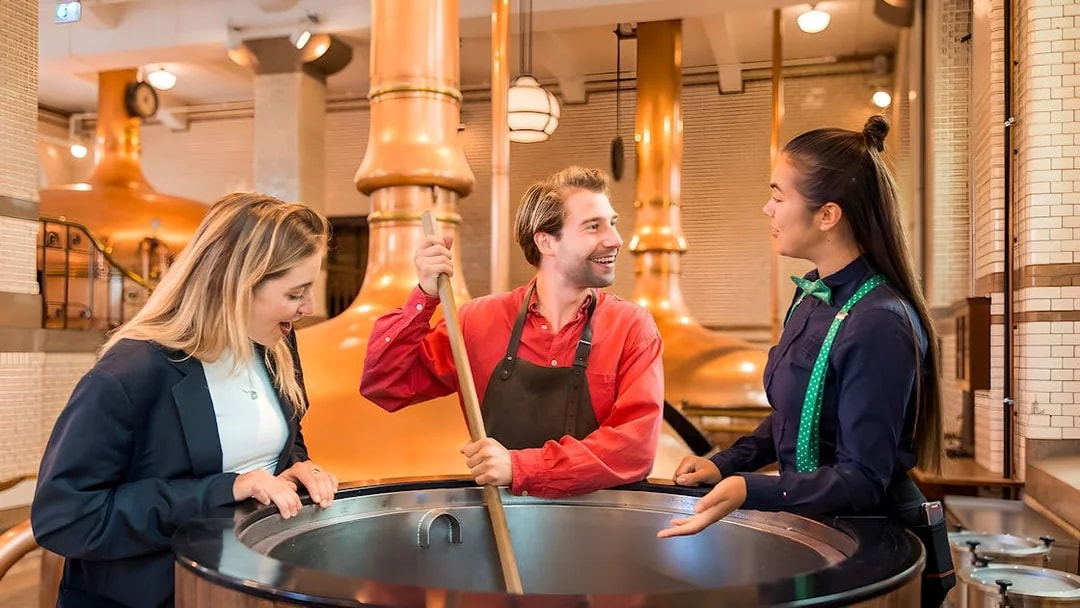 Guests with guide at brewing vat in Heineken Experience, Amsterdam.