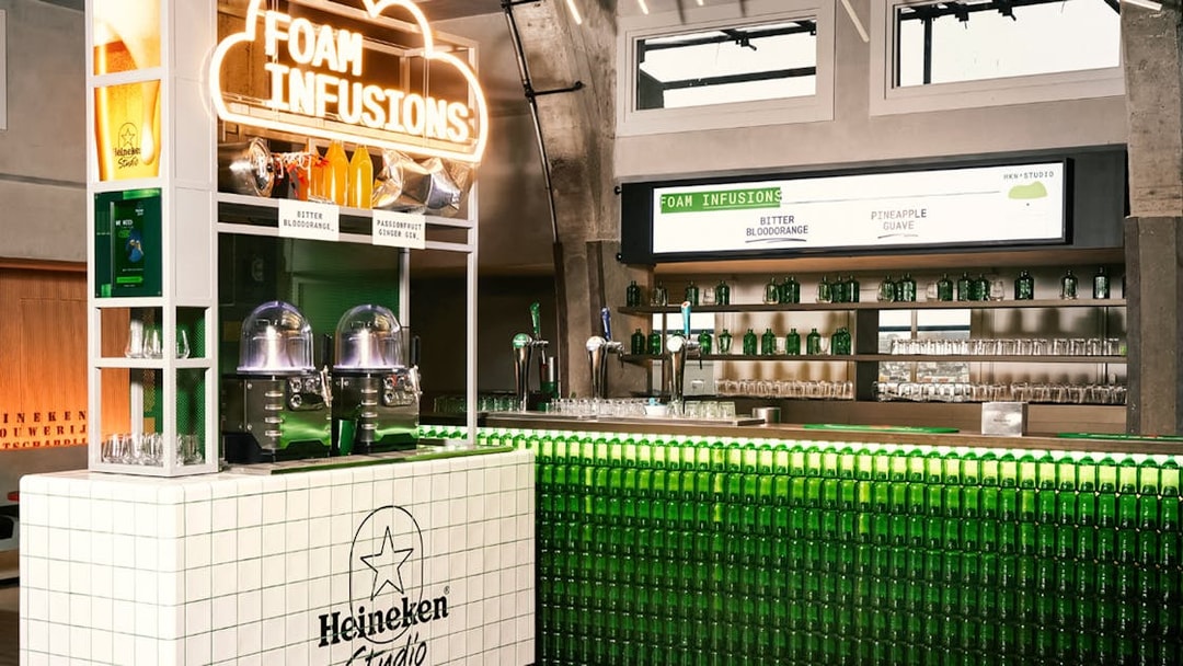 Heineken Experience interior with Foam Infusions bar and green bottle display.