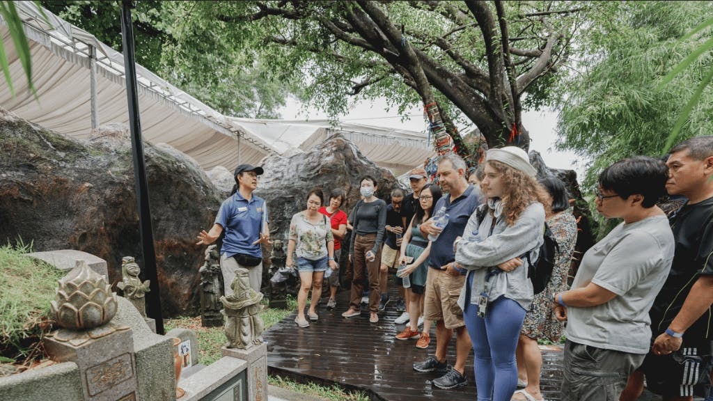 Tour group listens to guide by historic tombstone at Hell's Museum.