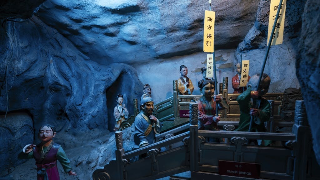 Diorama of figures crossing the Silver Bridge at Hell's Museum, depicting an afterlife scene.