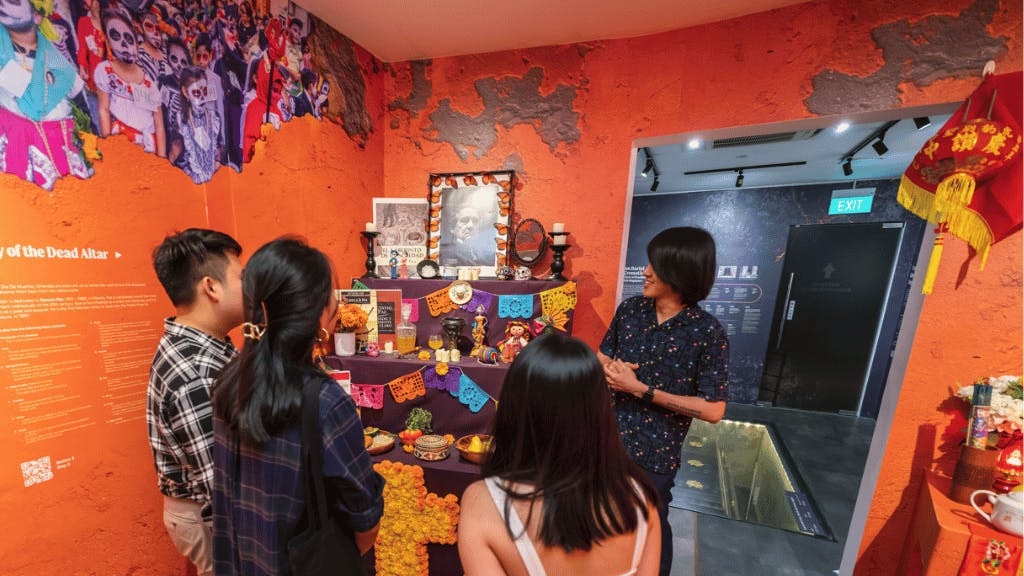 Visitors explore Day of the Dead altar exhibit at Singapore's Hell's Museum.