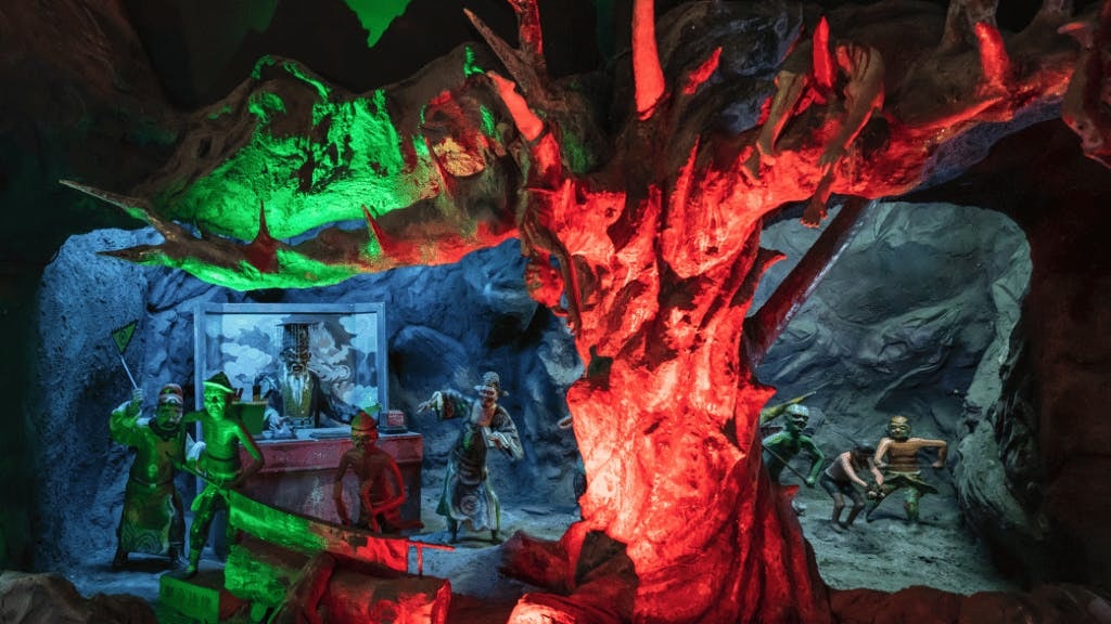 Diorama of underworld judgment scenes at Hell's Museum with vivid lighting effects.