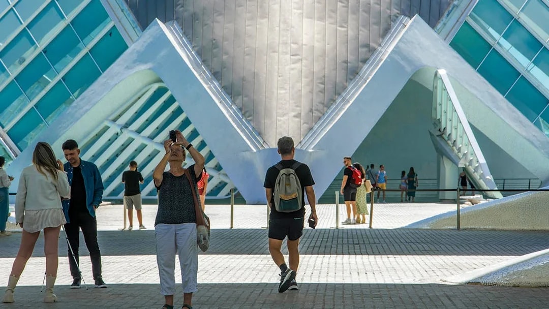 Visitors at Hemisfèric in Valencia, Spain, capturing photos of the modern architecture.