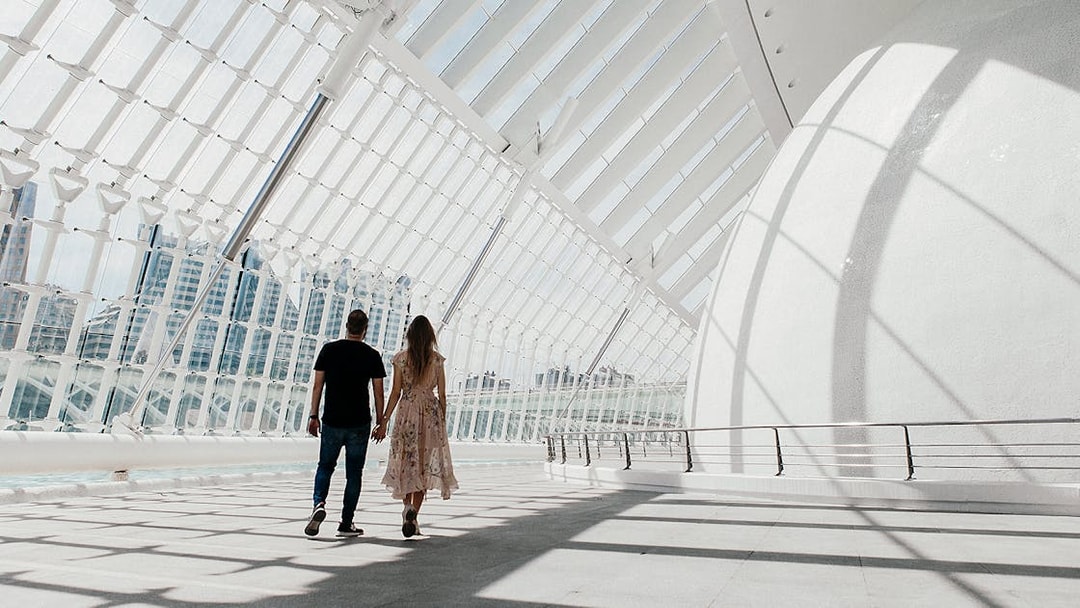 Couple walking inside Hemisfèric building, Valencia's City of Arts and Sciences.