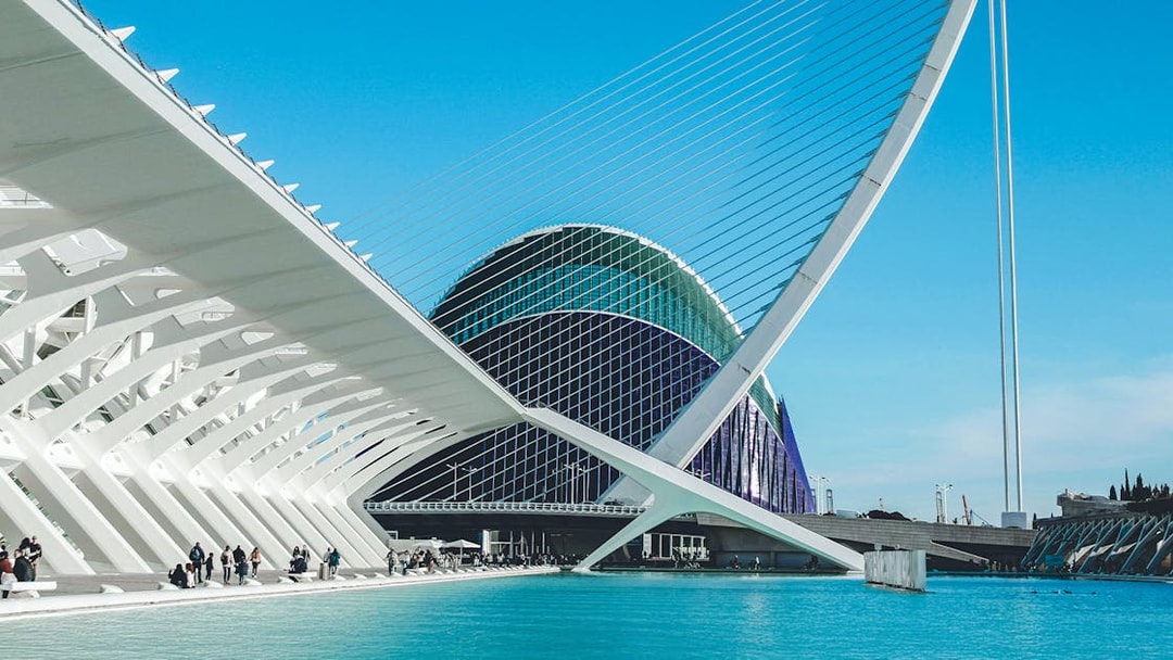 Hemisfèric architecture at City of Arts and Sciences, Valencia, with blue sky and water.