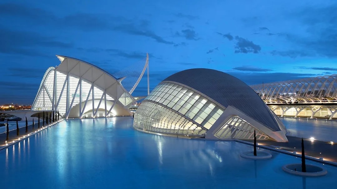 Oceanogràfic and Hemisfèric buildings in Valencia at dusk, reflecting in water.