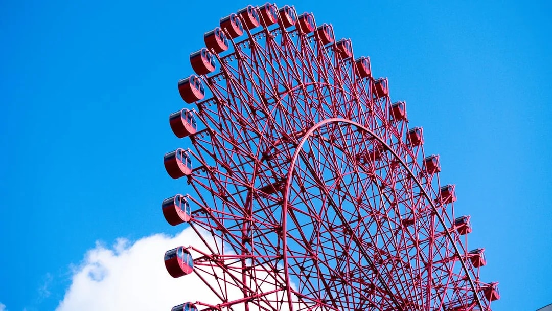 Red Ferris wheel against blue sky at HEP Five, Osaka.
