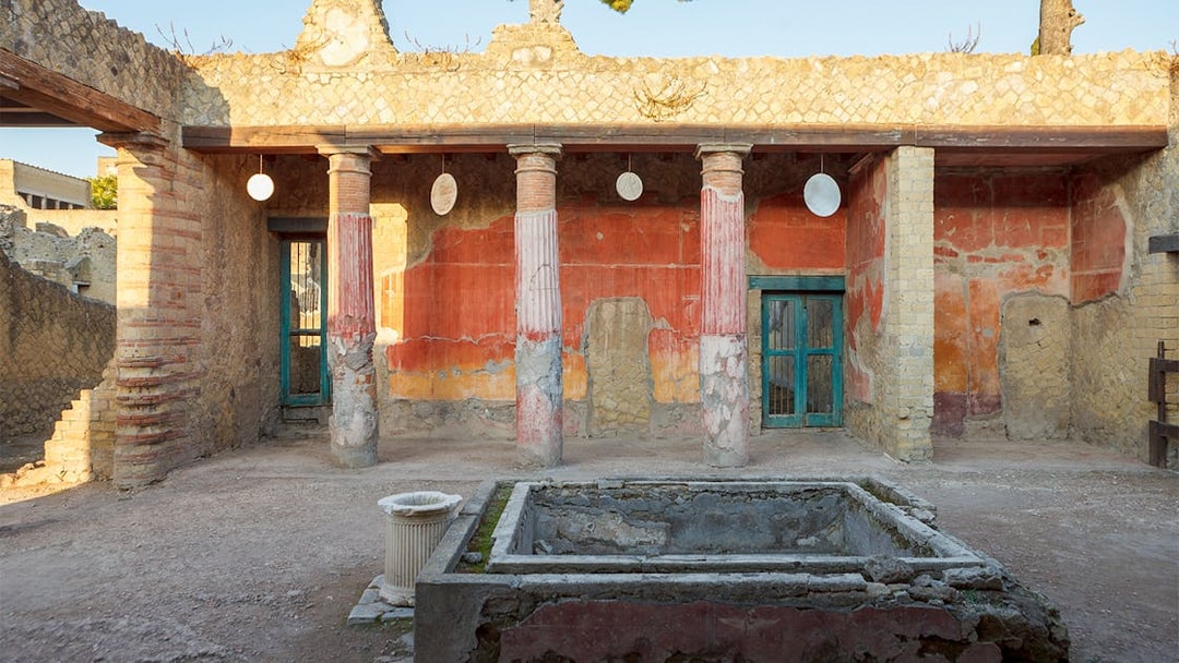 Ancient Herculaneum ruins with preserved columns and frescoes in Italy.