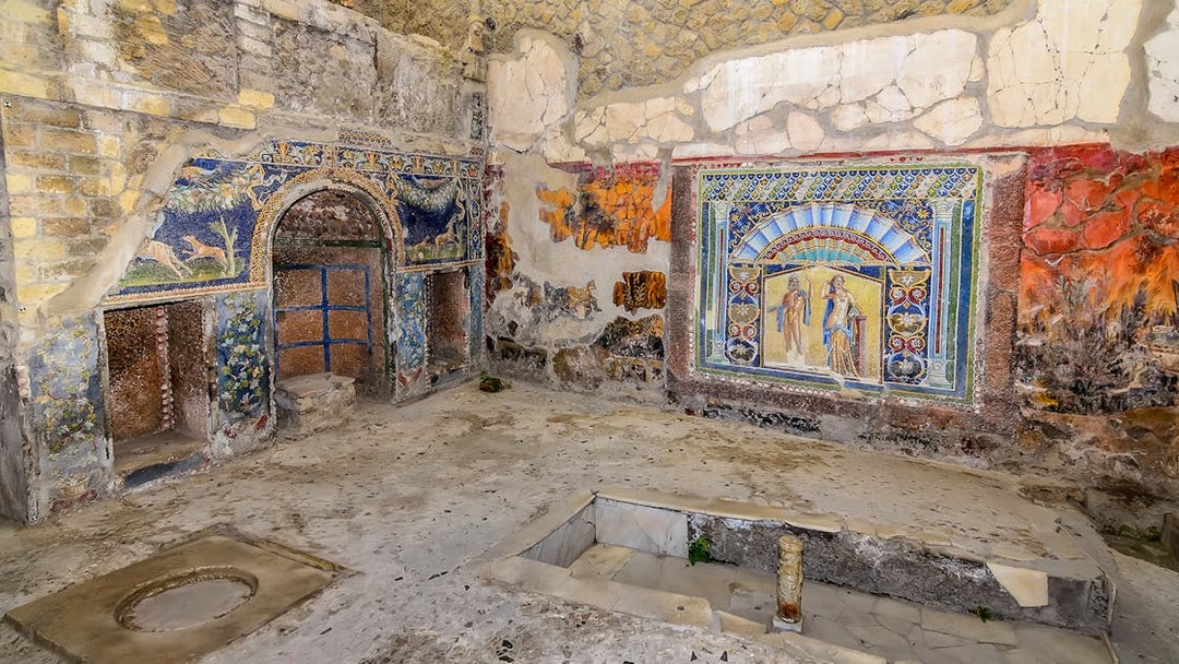 Remains of Herculaneum house interiors with frescoes and mosaics on walls.