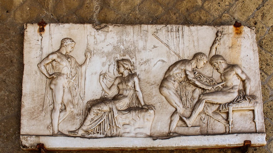 Bas-relief depicting ancient figures in Herculanum, Italy.