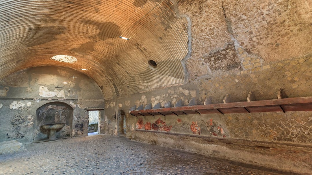 Thermae interior with vaulted ceiling and ancient stone basin, Herculaneum.