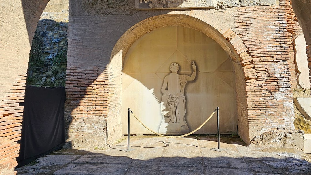 Herculaneum fresco depicting a figure in a toga on an ancient brick wall.