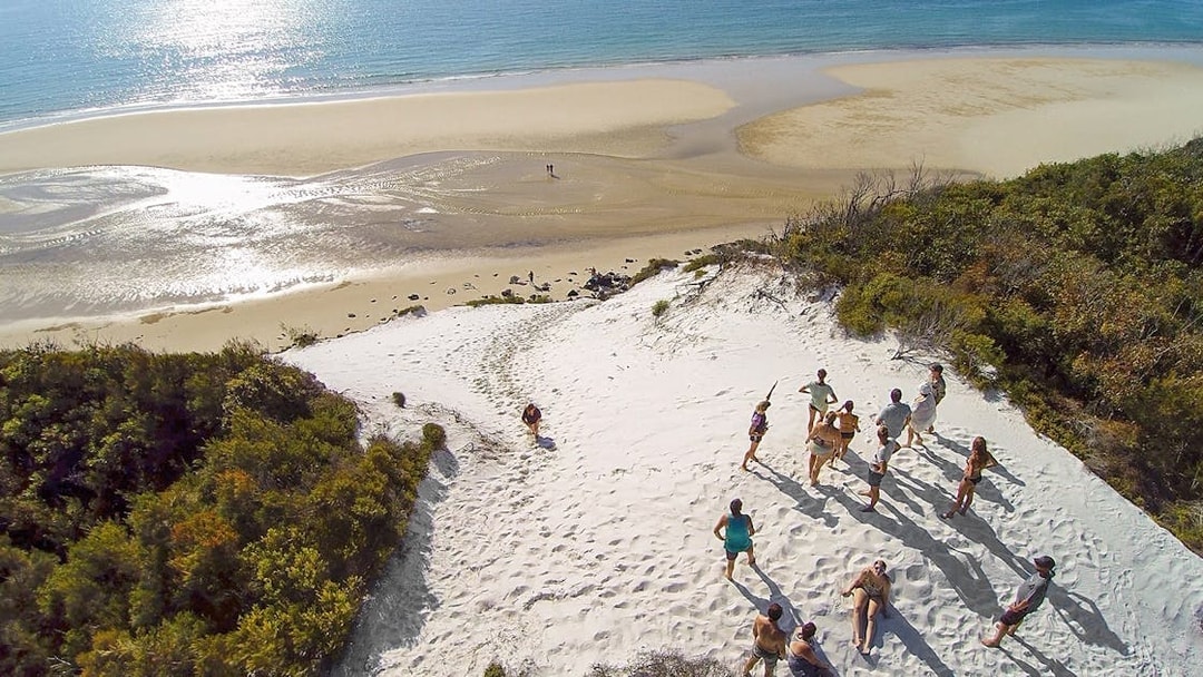 Group exploring sand dunes on K'gari (Fraser Island) during a full-day guided tour.