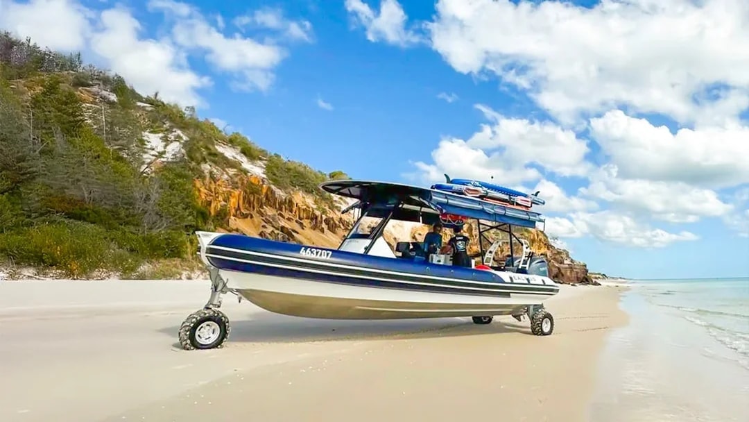 Sealegs boat on K'gari beach, Fraser Island, with coastal cliffs in the background.
