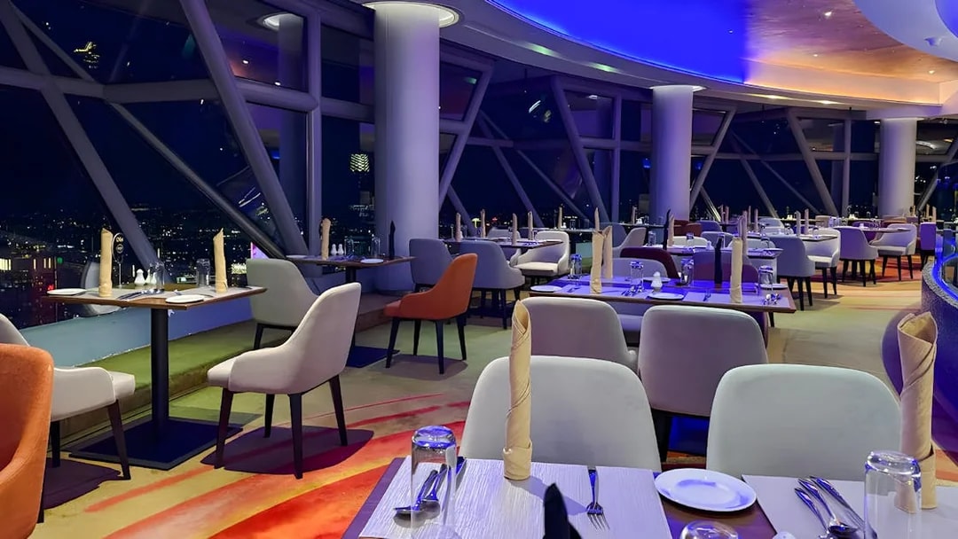 Dining area with city view at Orbit Revolving Restaurant, KL Tower, Kuala Lumpur, Malaysia.