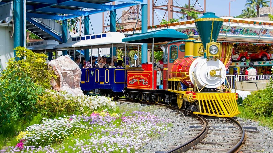 Colorful train ride at Hirakata Park, Japan, surrounded by flowers and greenery.