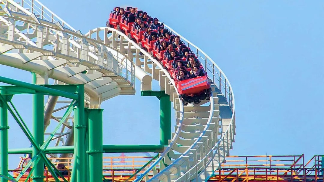 Roller coaster ride at Hirakata Park, Japan, with passengers on a steep track.