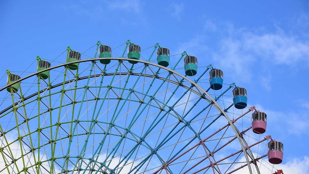 Ferris wheel at Hirakata Park against a blue sky.