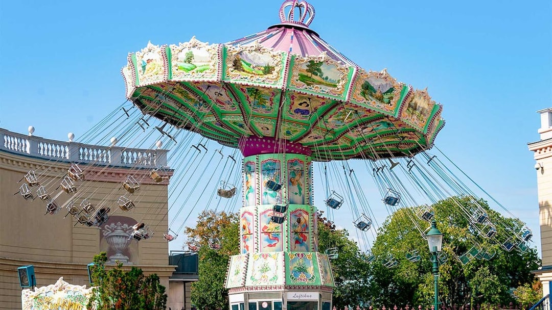 Carousel ride at Hirakata Park with colorful decorations and empty swing seats.