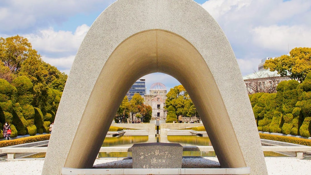 Memorial Cenotaph with Atomic Bomb Dome in Peace Memorial Park, Hiroshima.