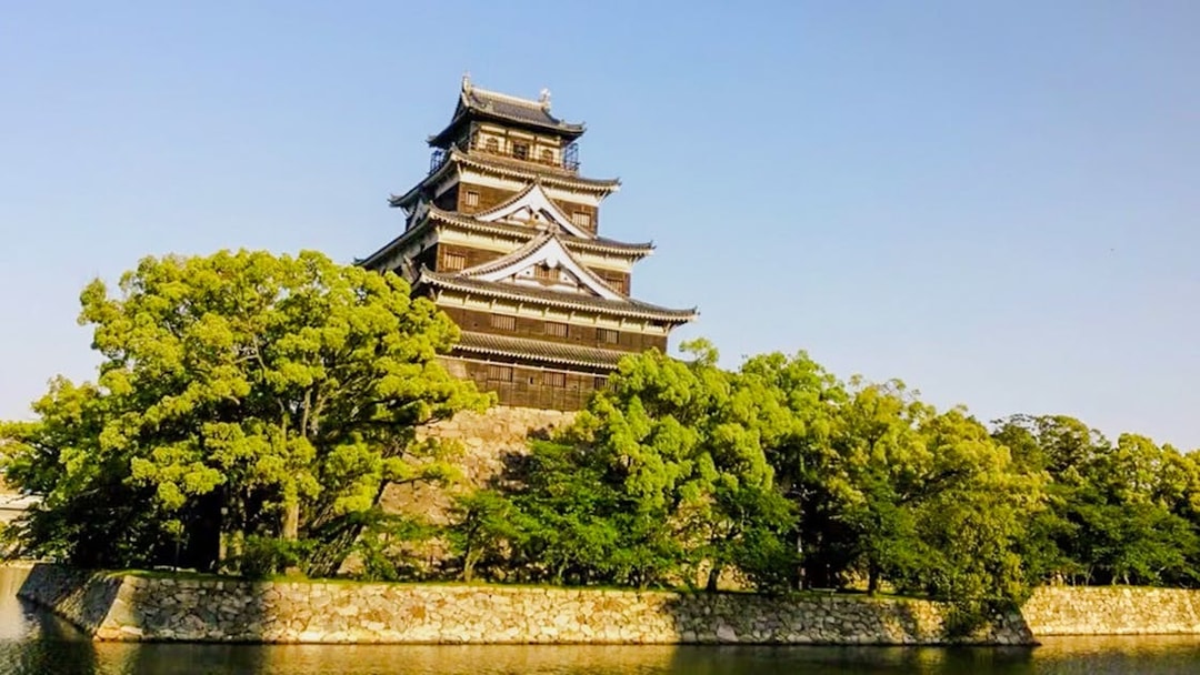 Hiroshima Castle surrounded by trees and a moat in Hiroshima, Japan.