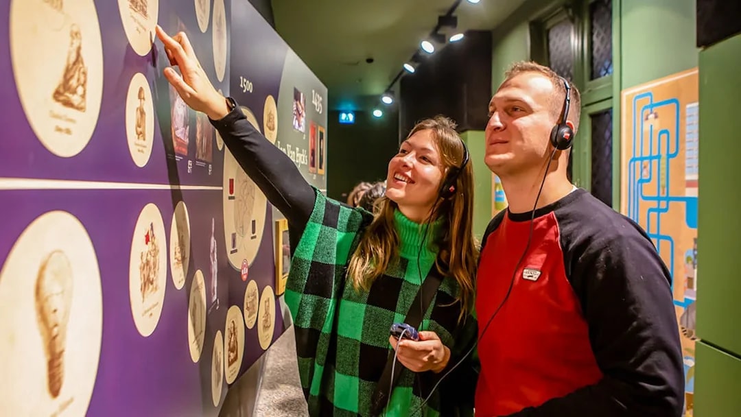 Visitors exploring exhibits at Historium Bruges with audio guides.