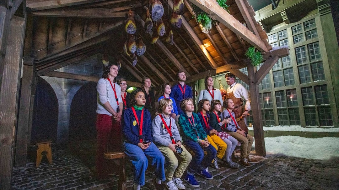 Guests watching a presentation at Historium Bruges under a wooden roof.