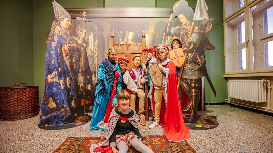 Guests in medieval costumes at Historium Bruges exhibit.