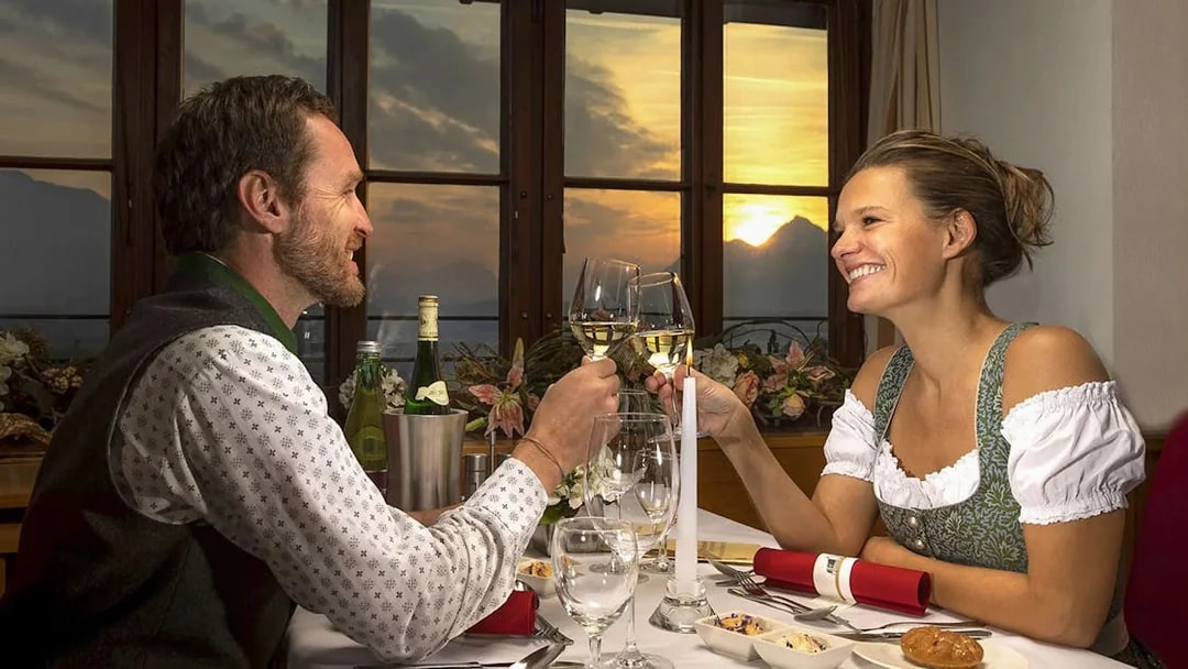 Couple toasting with wine at sunset dinner, Salzburg.