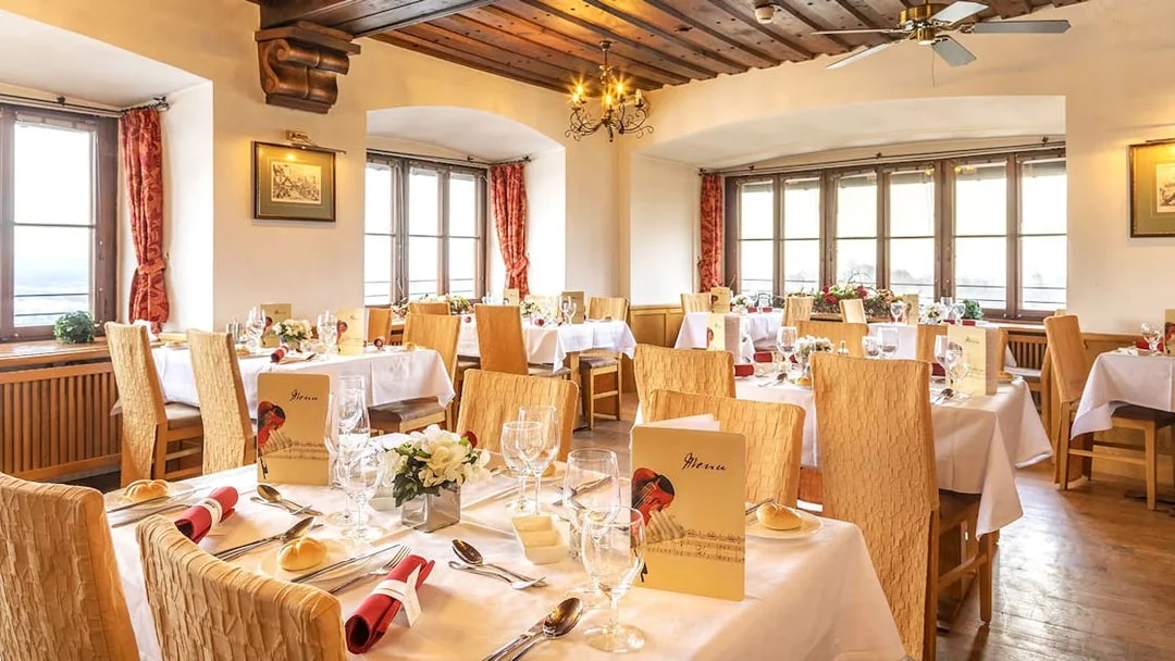 Dinner setup in Fortress Hohensalzburg dining room with tables and menus.
